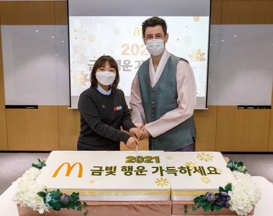 앤토니마티네즈(오른쪽) 한국맥도날드 대표와 서울시청점 김아영점장이 지난 4일 한국맥도날드 본사에서열린 신년맞이 첫 비대면 사내 타운홀 행사에서 떡 케이크 커팅식을 하고 있다. <한국맥도날드 제공>